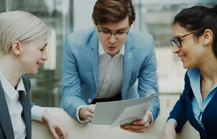 Colleagues in business attire review a document at a bright office table, City Service Index supports planning